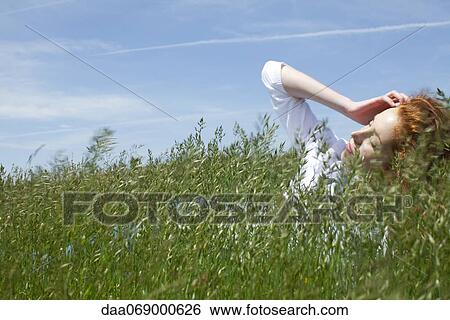 Woman lying in grass View Large Photo Image Stock Photograph - Woman lying in grass. Fotosearch
