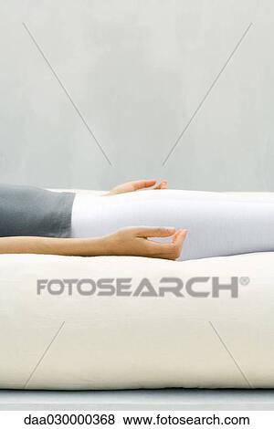 Woman lying on back, meditating, cropped view View Large Photo Image Stock Photo - Woman lying on back, meditating, cropped view. Fotosearch