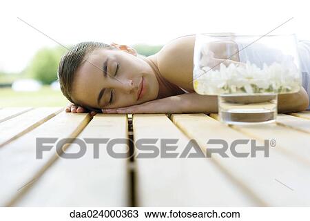 Woman lying on deck, next to container of floating flowers View Large Photo Image Stock Image - Woman lying on deck, next to container of floating flowers. Fotosearch