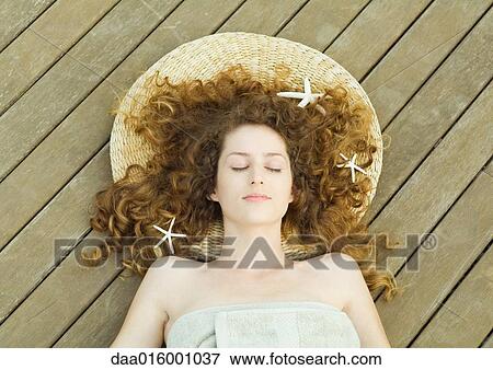 Woman lying on deck, wrapped in towel, head on mat, starfish in hair View Large Photo Image Stock Photo - Woman lying on deck, wrapped in towel, head on mat, starfish in hair. Fotosearch