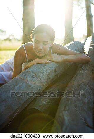 Woman lying on pile of logs View Large Photo Image Stock Photo - Woman lying on pile of logs. Fotosearch