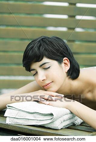 Woman lying on stomach, head on hands View Large Photo Image Picture - Woman lying on stomach, head on hands. Fotosearch