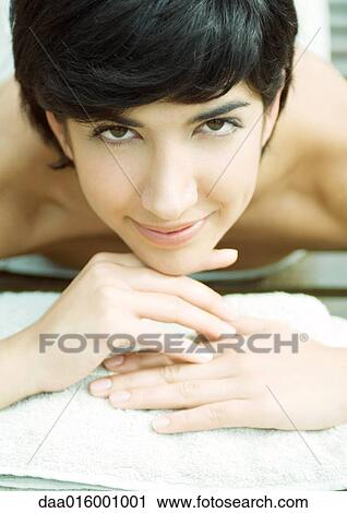 Woman lying on stomach, head on hands View Large Photo Image Stock Image - Woman lying on stomach, head on hands. Fotosearch