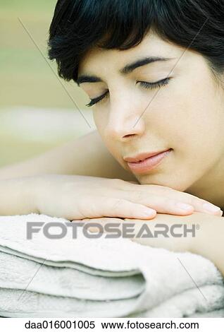 Stock Photography - Woman lying on stomach, head on hands. Fotosearch