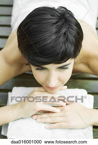 Woman lying on stomach, wrapped in towel, head on hands View Large Photo Image Stock Image - Woman lying on stomach, wrapped in towel, head on hands. Fotosearch