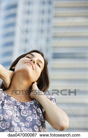 Woman massaging her neck, eyes closed View Large Photo Image Stock Photo - Woman massaging her neck, eyes closed. Fotosearch