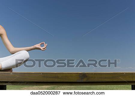 Stock Photo - Woman meditating in lotus position outdoors, cropped. Fotosearch