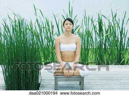 Picture - Woman meditating outdoors. Fotosearch