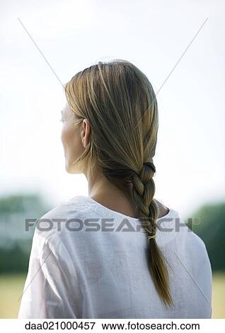 Stock Photo - Woman outdoors, hair braided, rear view. Fotosearch