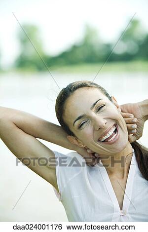 Woman outdoors, hands behind head, laughing, head and shoulders View Large Photo Image Stock Photograph - Woman outdoors, hands behind head, laughing, head and shoulders. Fotosearch