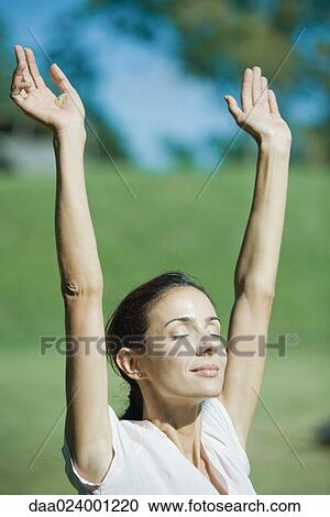 Woman outdoors in sun with arms raised, smiling, eyes closed View Large Photo Image Stock Image - Woman outdoors in sun with arms raised, smiling, eyes closed. Fotosearch