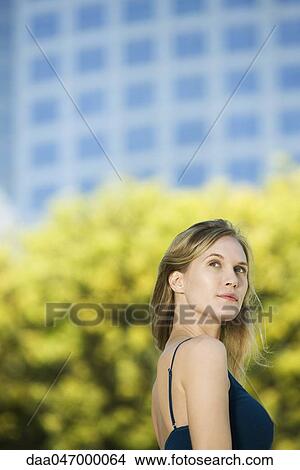 Woman outdoors, looking up dreamily, portrait View Large Photo Image Picture - Woman outdoors, looking up dreamily, portrait. Fotosearch