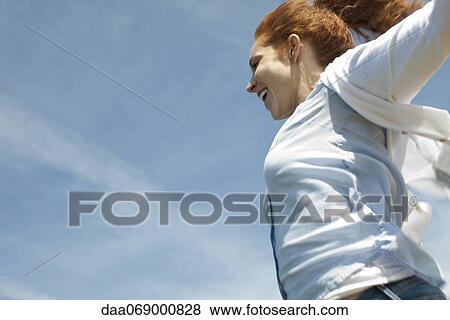 Woman outdoors with arms out, cropped View Large Photo Image Stock Photo - Woman outdoors with arms out, cropped. Fotosearch