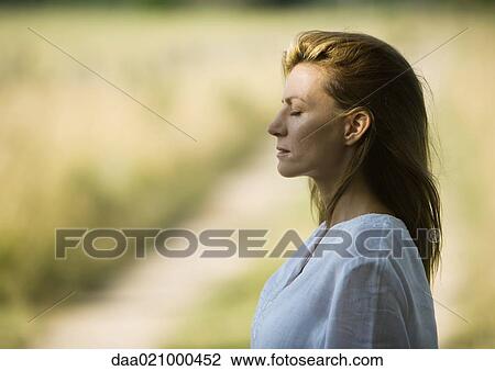 Stock Image - Woman outdoors with eyes closed, head and shoulders, profile. Fotosearch