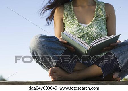 Woman reading book outdoors, cropped View Large Photo Image Stock Photo - Woman reading book outdoors, cropped. Fotosearch