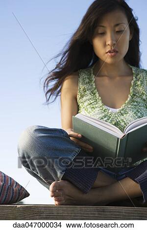 Woman reading book outdoors View Large Photo Image Picture - Woman reading book outdoors. Fotosearch