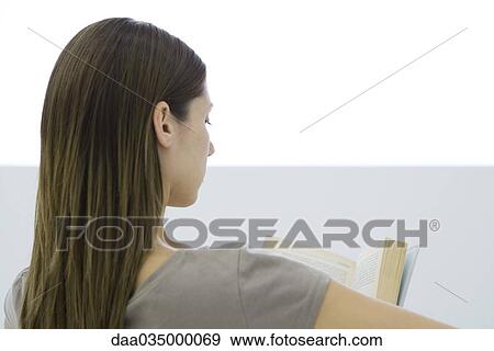 Stock Photo - Woman reading book, rear view. Fotosearch
