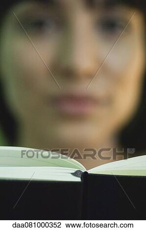 Stock Image - Woman reading, focus on book. Fotosearch