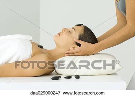 Woman receiving massage and hot stone treatment, close-up View Large Photo Image Stock Photo - Woman receiving massage and hot stone treatment, close-up. Fotosearch