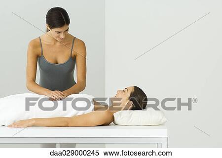 Stock Photography - Woman receiving massage, chatting with massage therapist. Fotosearch