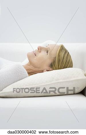 Woman reclining on sofa, looking up, profile View Large Photo Image Stock Image - Woman reclining on sofa, looking up, profile. Fotosearch