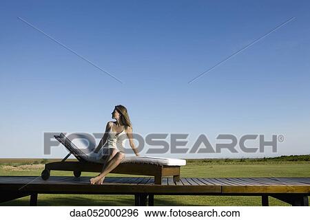 Woman relaxing on lounge chair outdoors View Large Photo Image Stock Photograph - Woman relaxing on lounge chair outdoors. Fotosearch