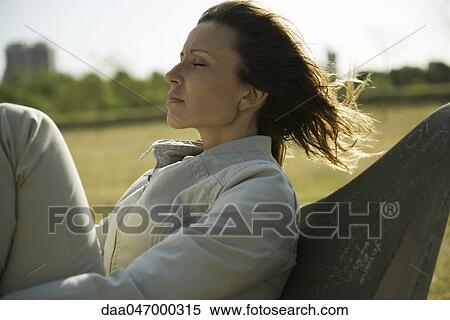 Woman relaxing outdoors, eyes closed View Large Photo Image Stock Photography - Woman relaxing outdoors, eyes closed. Fotosearch