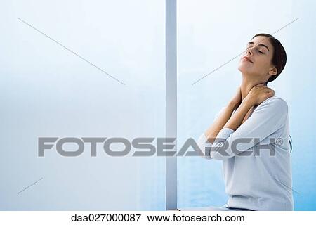 Stock Photo - Woman relaxing with hands behind neck, head back and eyes closed, waist up. Fotosearch