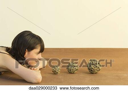 Woman resting head on arms, looking at balls of string, side view View Large Photo Image Stock Image - Woman resting head on arms, looking at balls of string, side view. Fotosearch