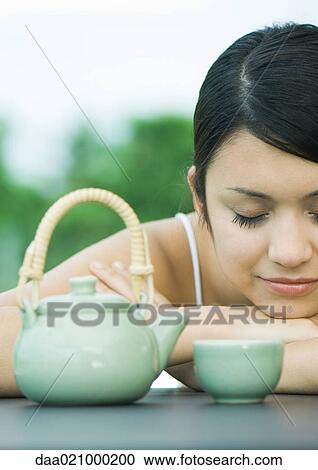 Woman resting head on arms near tea service View Large Photo Image Stock Image - Woman resting head on arms near tea service. Fotosearch