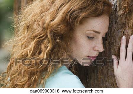 Woman resting head on tree trunk View Large Photo Image Stock Photo - Woman resting head on tree trunk. Fotosearch