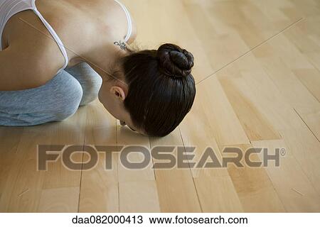 Stock Image - Woman resting in child's pose. Fotosearch