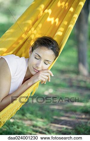 Woman resting in hammock, eyes closed View Large Photo Image Stock Image - Woman resting in hammock, eyes closed. Fotosearch