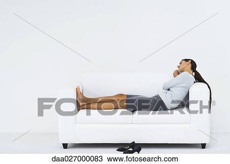 Woman resting on sofa, full length View Large Photo Image Stock Image - Woman resting on sofa, full length. Fotosearch
