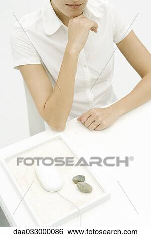 Woman sitting at desk, computer mouse nearby in rock garden, high angle view, cropped View Large Photo Image Stock Photograph - Woman sitting at desk, computer mouse nearby in rock garden, high angle view, cropped. Fotosearch