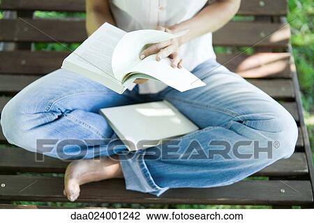 Woman sitting barefoot on bench, reading book View Large Photo Image Stock Image - Woman sitting barefoot on bench, reading book. Fotosearch