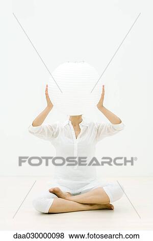 Woman sitting cross-legged on the ground, holding paper lantern in front of face View Large Photo Image Stock Photo - Woman sitting cross-legged on the ground, holding paper lantern in front of face. Fotosearch
