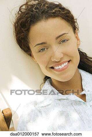 Woman sitting in deck chair, smiling at camera, portrait View Large Photo Image Stock Photo - Woman sitting in deck chair, smiling at camera, portrait. Fotosearch