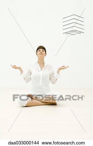 Picture - Woman sitting in lotus position, eyes closed. Fotosearch