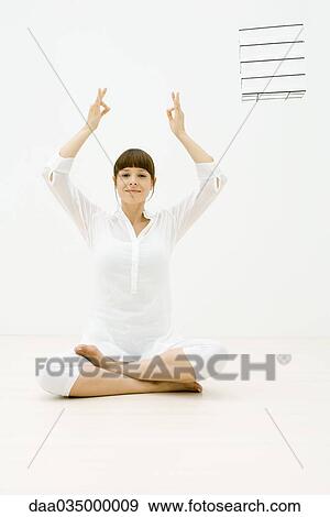 Woman sitting in lotus position on floor, arms raised View Large Photo Image Stock Photo - Woman sitting in lotus position on floor, arms raised. Fotosearch