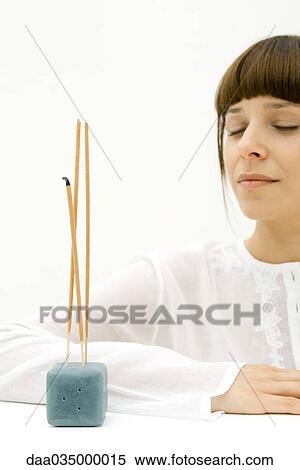 Woman sitting near incense, eyes closed View Large Photo Image Stock Photography - Woman sitting near incense, eyes closed. Fotosearch