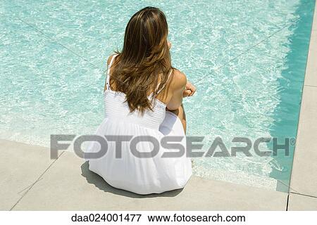 Woman sitting on edge of pool, rear view View Large Photo Image Stock Photo - Woman sitting on edge of pool, rear view. Fotosearch