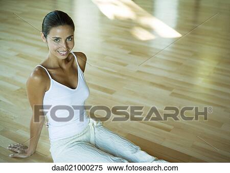 Woman sitting on floor of exercise studio, smiling at camera View Large Photo Image Stock Photography - Woman sitting on floor of exercise studio, smiling at camera. Fotosearch