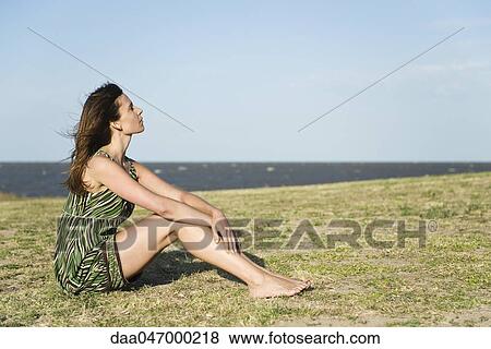 Woman sitting on grass barefoot, relaxing View Large Photo Image Stock Photo - Woman sitting on grass barefoot, relaxing. Fotosearch