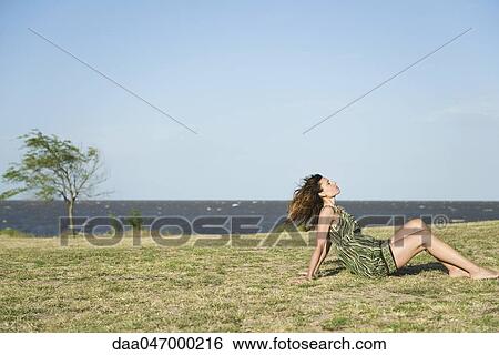Woman sitting on grass barefoot, relaxing View Large Photo Image Stock Photograph - Woman sitting on grass barefoot, relaxing. Fotosearch