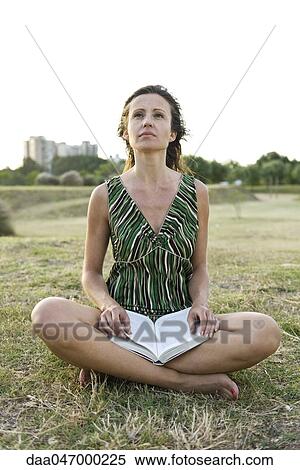 Woman sitting on grass, reading book View Large Photo Image Stock Photography - Woman sitting on grass, reading book. Fotosearch