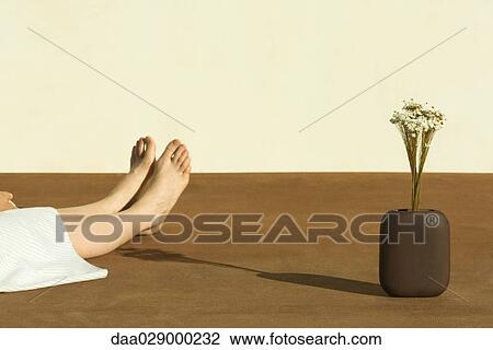 Woman sitting on the ground next to flowers in vase, cropped view View Large Photo Image Stock Image - Woman sitting on the ground next to flowers in vase, cropped view. Fotosearch