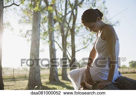 Woman sitting on top of log pile View Large Photo Image Stock Image - Woman sitting on top of log pile. Fotosearch
