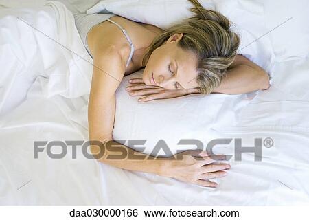 Woman sleeping on bed, high angle view View Large Photo Image Stock Photograph - Woman sleeping on bed, high angle view. Fotosearch