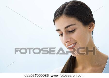Woman smiling, looking down, head and shoulders, portrait View Large Photo Image Stock Photograph - Woman smiling, looking down, head and shoulders, portrait. Fotosearch